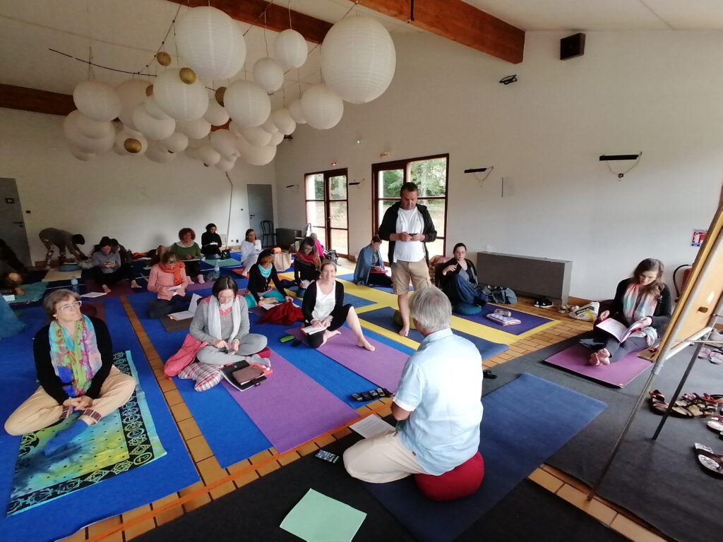 Salle de yoga avec les élèves sur leurs tapis